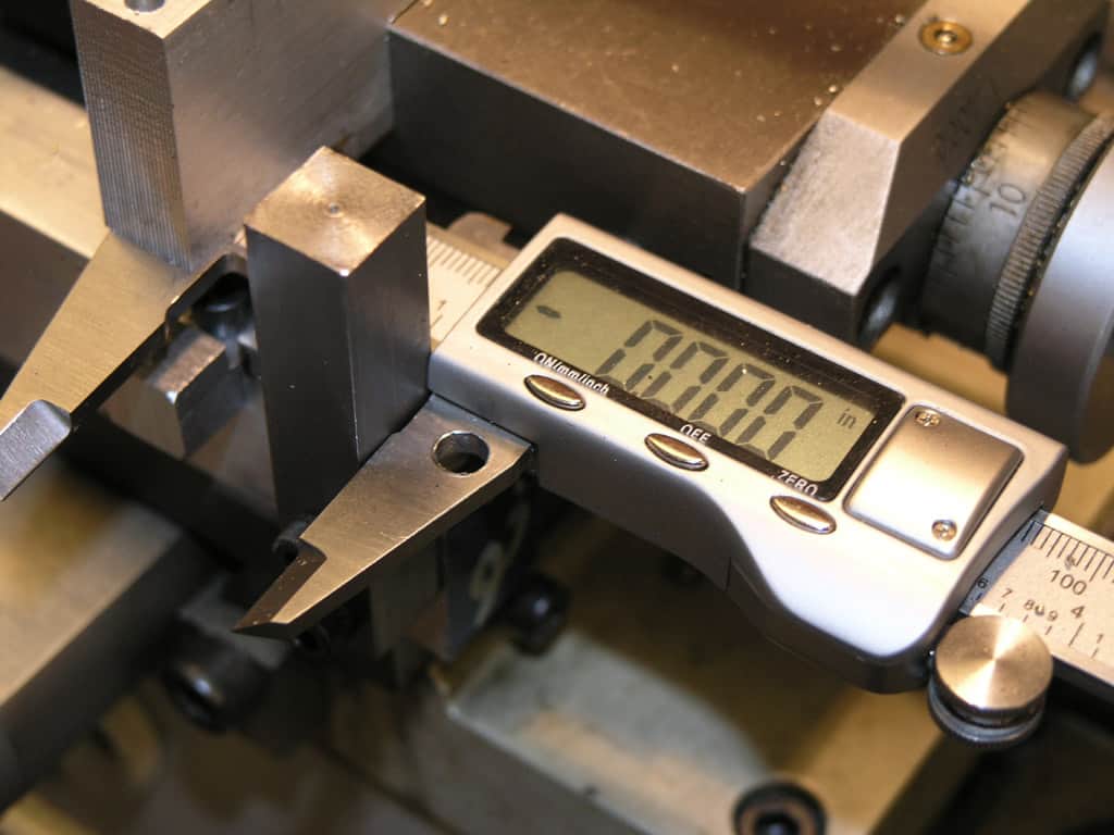 A digital caliper in an industrial setting with display screen reading "0.000".