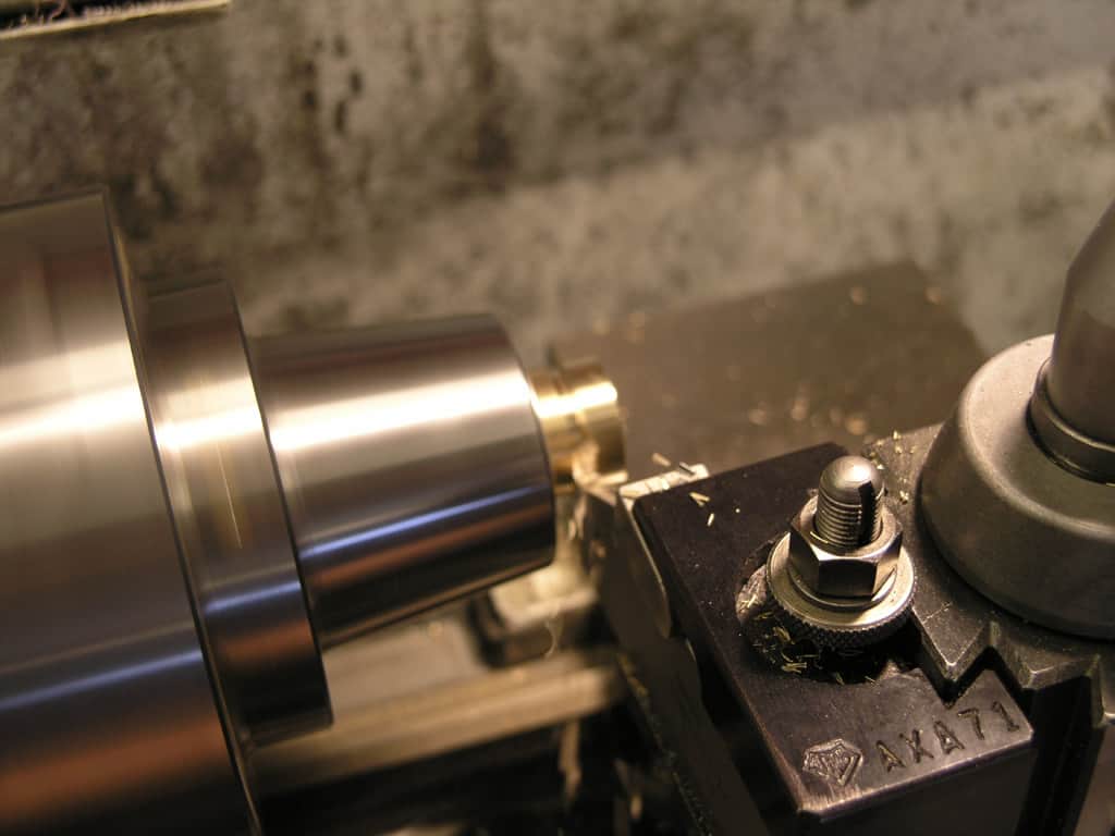 Metal object being machined on a lathe in a machine shop.
