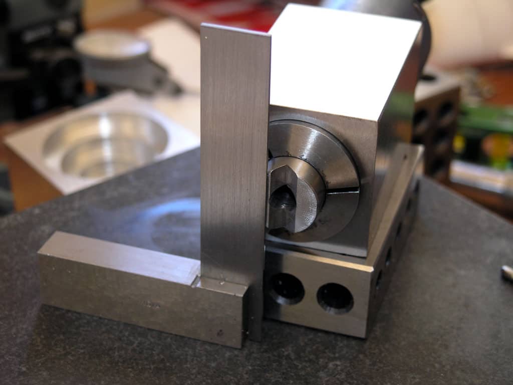 A metal vise with sturdy base and vice jaw on a workbench.