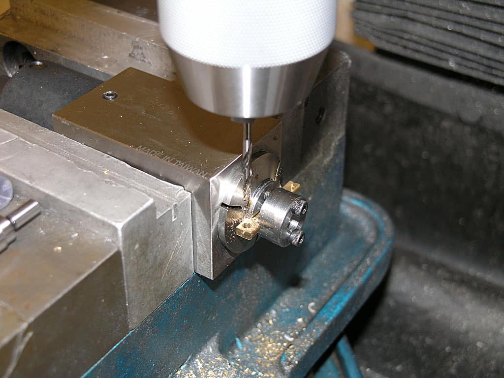 Metalworking machine with drill bit and metal shavings.