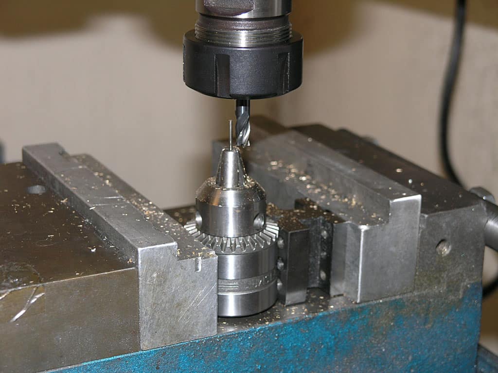 Metalworking drill bit in use, attached to machinery.