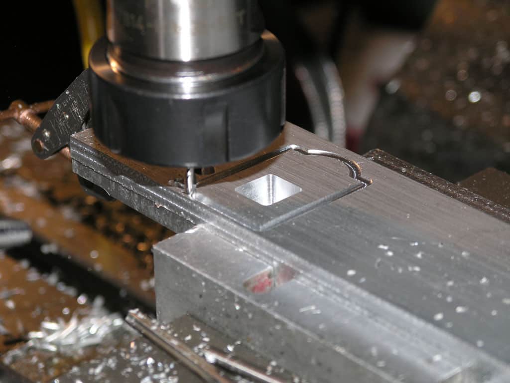 Metalworking machine in operation on a white background.