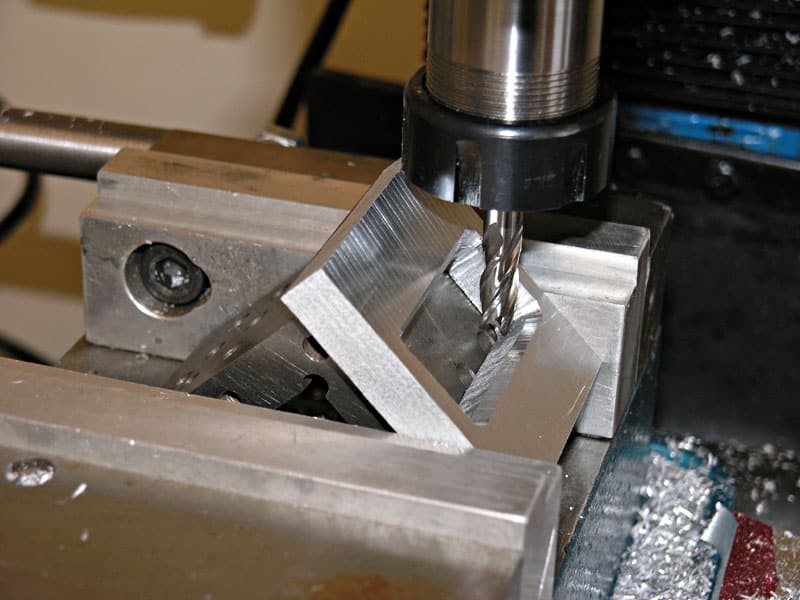 Metalworking machine with drill bit in place, surrounded by metal shavings.