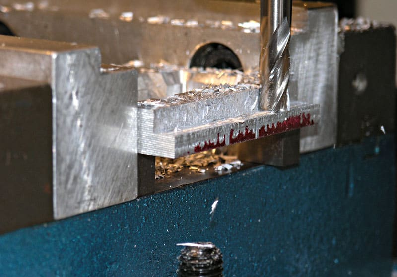 A blue metal working bench with silver metal parts attached.