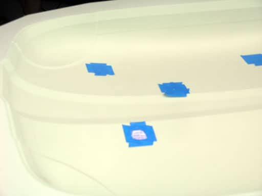 Three small, circular pinholes in a white metal or plastic surface.