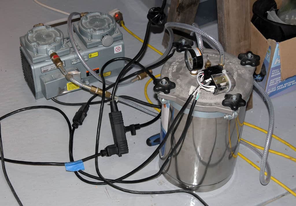 Stainless steel pressure vessel with vacuum pump system and metalworking equipment.