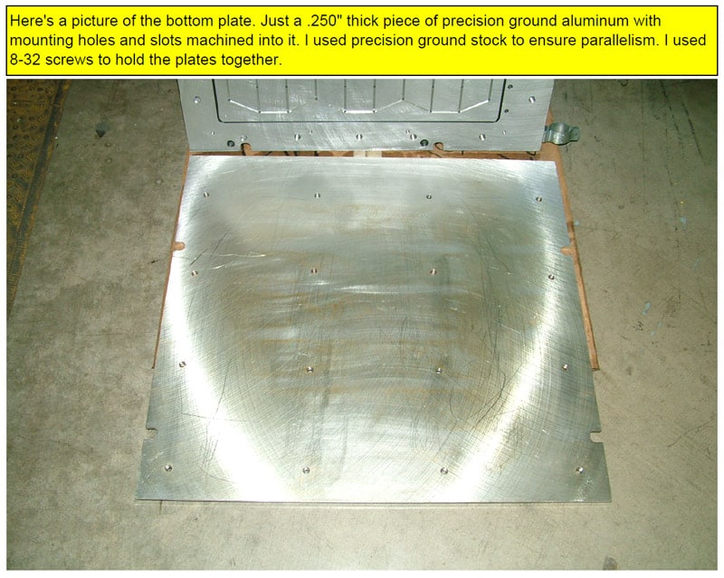 Large metal plate with brushed finish and drilled holes on a concrete floor.