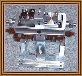 Silver metal device with rectangular base and two horizontal bars.