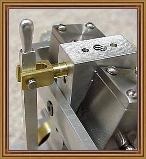 Stainless steel metal component with attached lever handle.