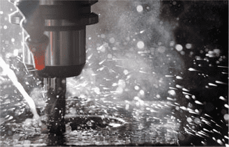 A drill bit cutting through metal on a CNC machine.