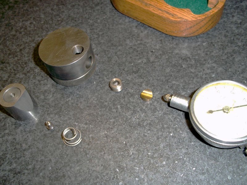 Precision measurement tools such as micrometers and calipers arranged on a gray surface.