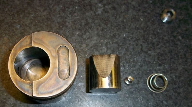 Metal parts, including a bronze-colored object with a circular hole.