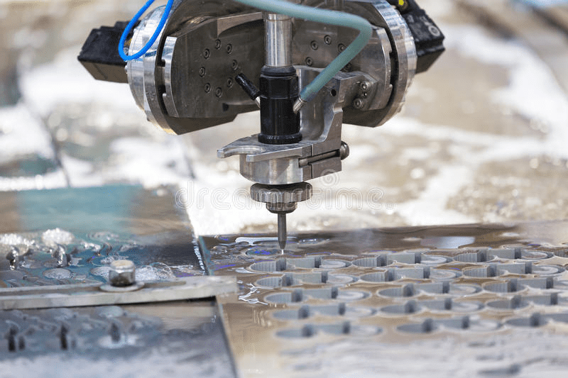 Industrial waterjet cutting machine in action, with blue hose, metal parts, and nozzle.