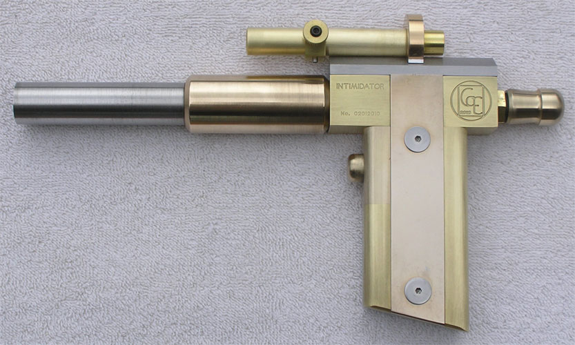 Brass pistol with "INTIMIDATOR" engraved cylinder, silver barrel, and circular logo on handle.