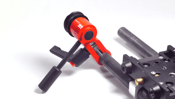 A black and red metalworking tool with a cylindrical body and two arms extending from the top.