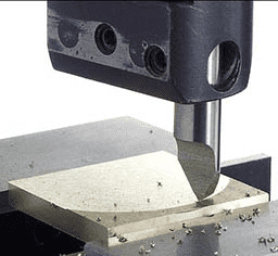 A close-up photograph of a metal cutting tool, likely an end mill or router bit, in use.