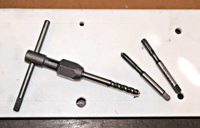 Metal cutting tools: tap, reamer, drill bits.