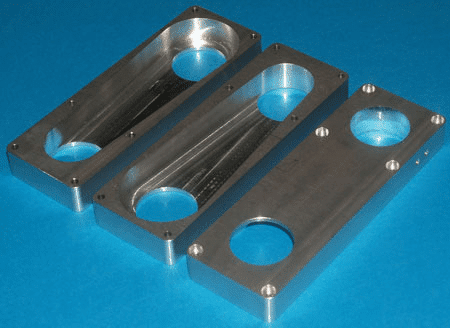 A rectangular metal part with rounded corners and two circular holes on a blue background.