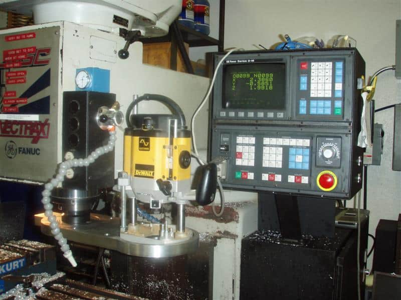 Computer numerical control (CNC) router machine in a workshop with control panel and cutting head.