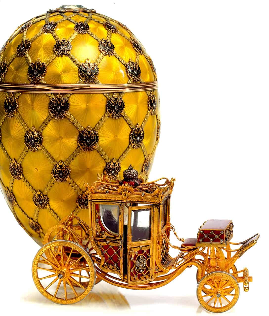 Golden carriage with intricately designed details and a large egg-shaped object behind it.