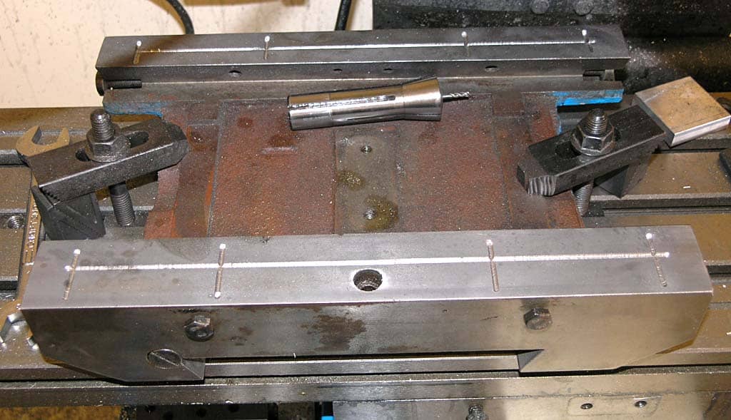 Heavy-duty metalworking vise with adjustable jaw and clamps.