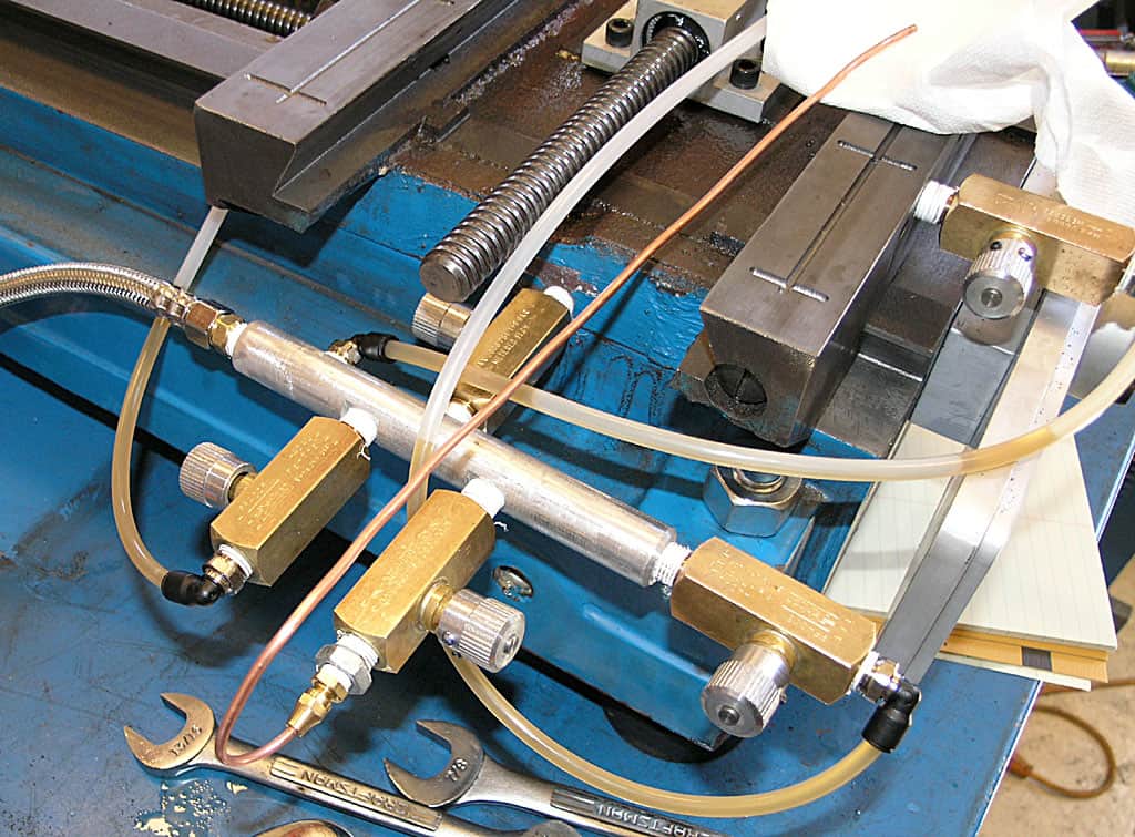 Machining tools and equipment on a blue workbench in a metal fabrication setting.