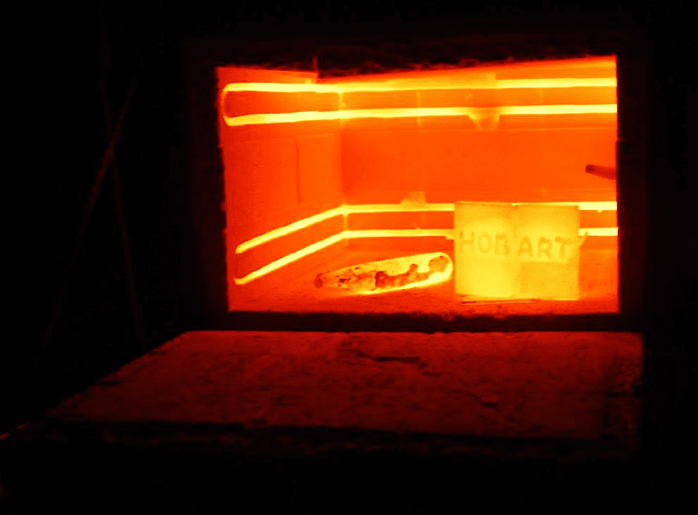 Rectangular kiln with orange glow and "HON ART" sign.