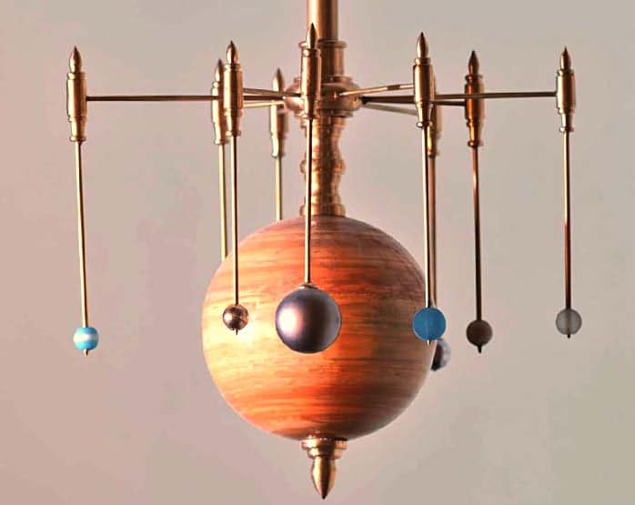 Blue plastic balls representing planets in our solar system orbiting around a central sphere.