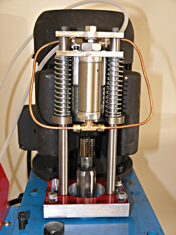 Mechanical device with blue base plate, copper tubing, and metal components.