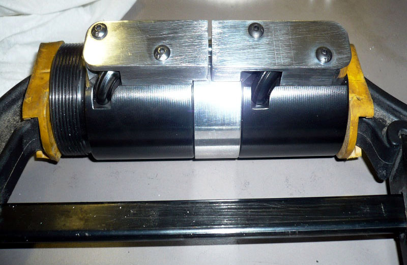 Mechanical component with black cylindrical body, silver metal pieces, and yellow plastic parts.