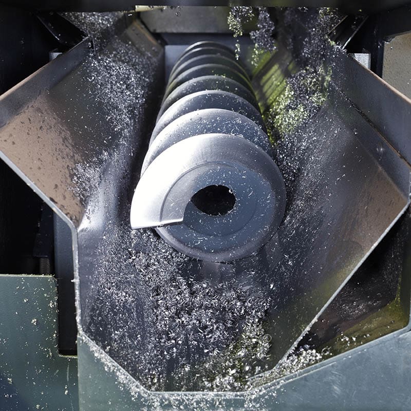 Black metal spiral auger with metal shavings.