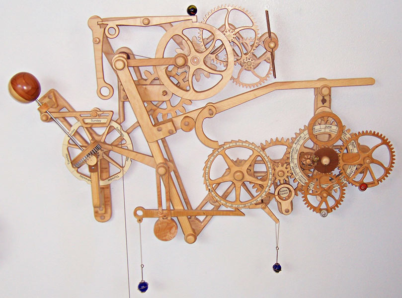 Complex mechanical device with interlocking gears and levers made from light-colored wood or plastic.