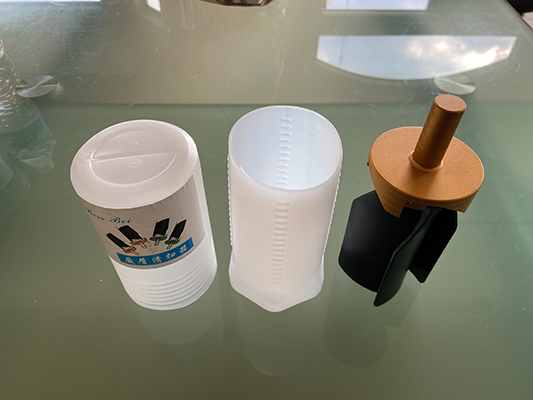 Two cylindrical objects with labels: one white with Chinese characters, one gold.