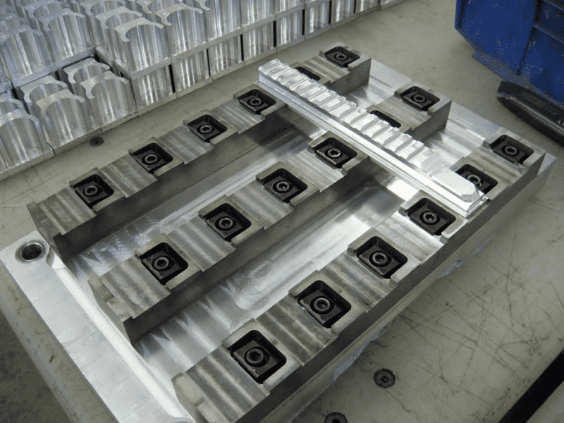 Large metal plate with multiple square-shaped holes.