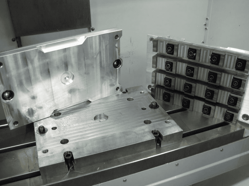 Machining fixture with metal plates and holes.