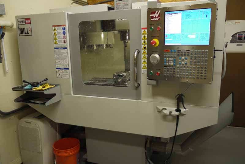 Industrial CNC machine with control panel and display.