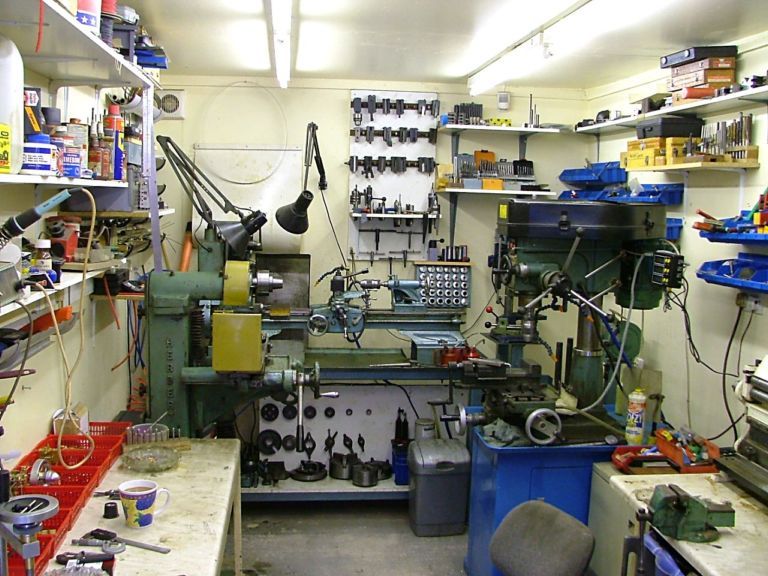 Cluttered workshop with various machinery and tools.