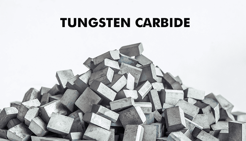 Tungsten carbide chips or pieces on a metal work surface.