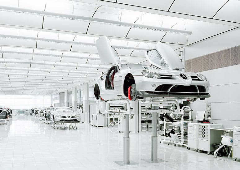 A modern car factory with rows of machinery and equipment in a well-lit all-white space.