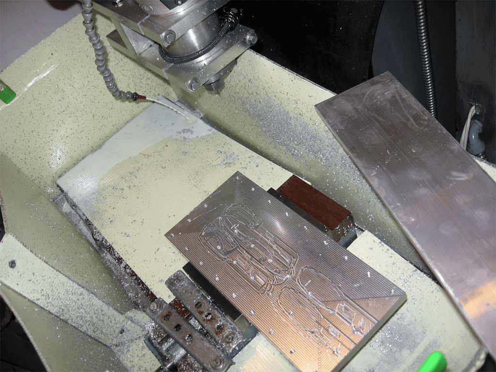 Metalworking machine with metal block, "CS" logo, and machining tools.