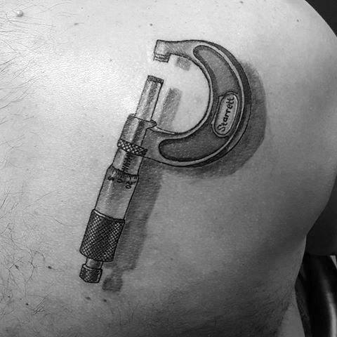 A black-and-white image of a man's back with a detailed tattoo resembling a micrometer.