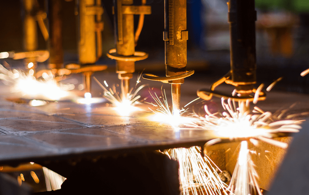 Laser cutting and plasma cutting with sparks on a CNC machine setup.