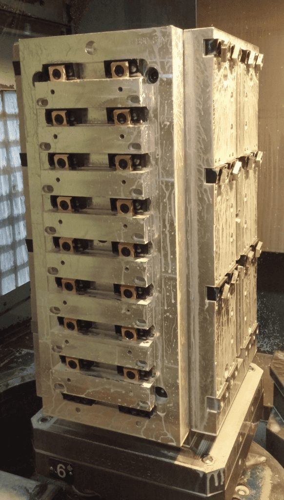 Metal parts with holes stacked vertically.