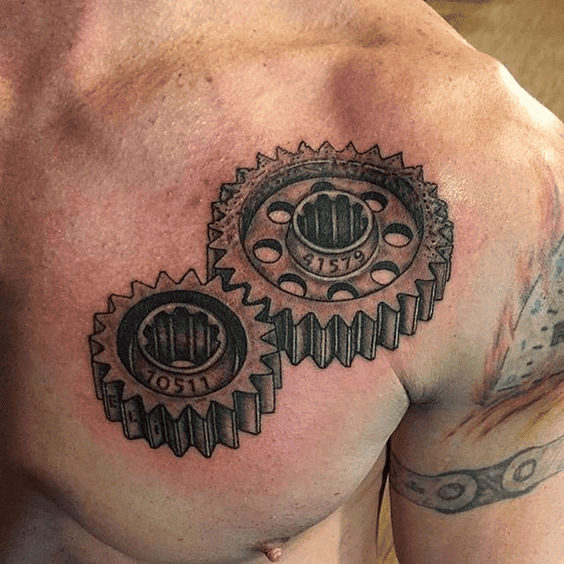 A man with tattoos of two black-and-white gears on his chest.
