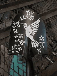 Black metal object with a white stylized hummingbird design on a textured background.