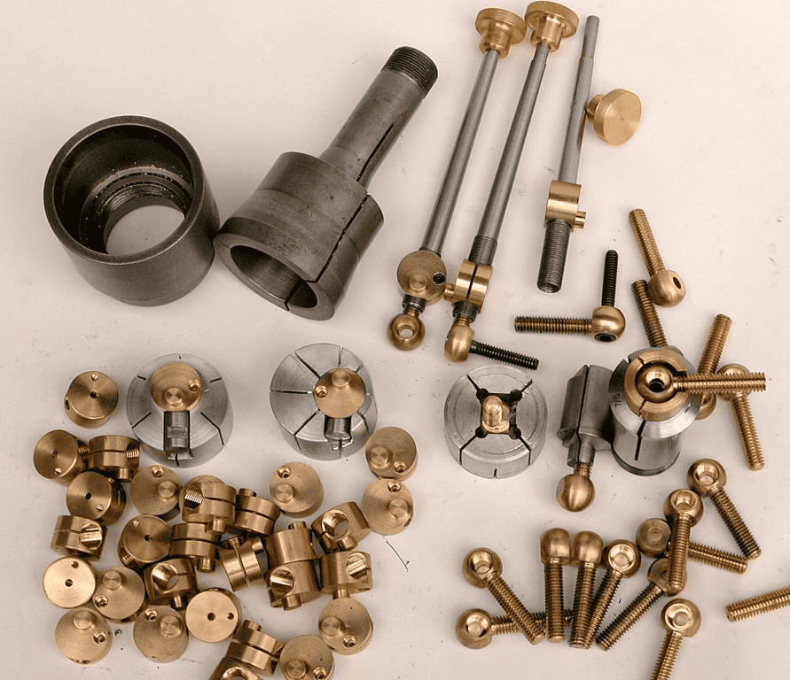 Metallic components, cylindrical pieces, threaded ends, round brass/knob, metal parts.