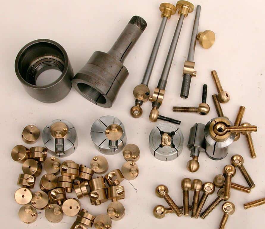 Brass and steel hardware components including bolts, nuts and assorted metal parts.