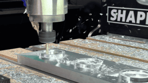 Metal workpiece being machined by a milling machine or CNC router.