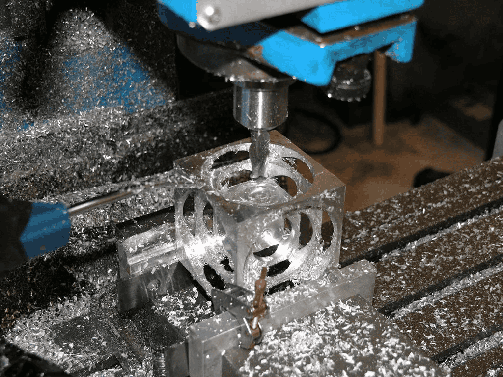 Metal object being machined on a milling machine.