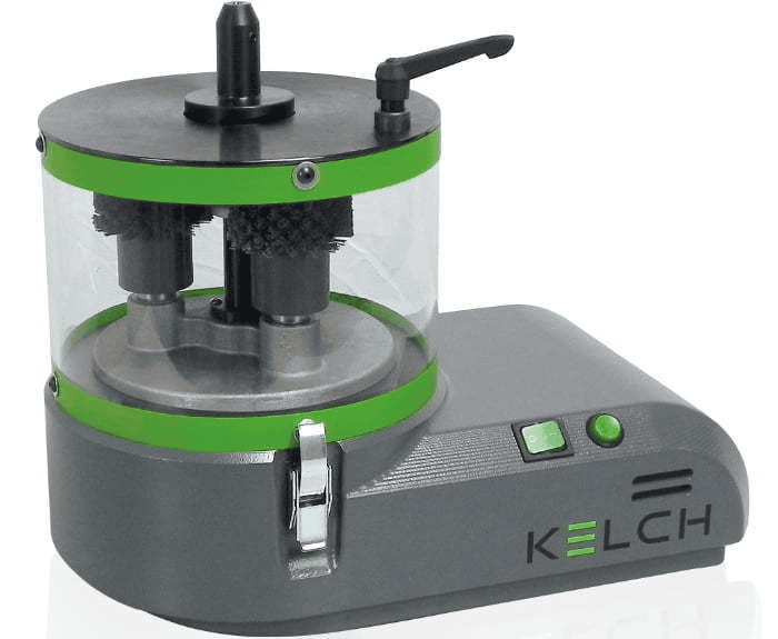 Cylindrical metalworking tool with clear plastic container and two black brushes inside.